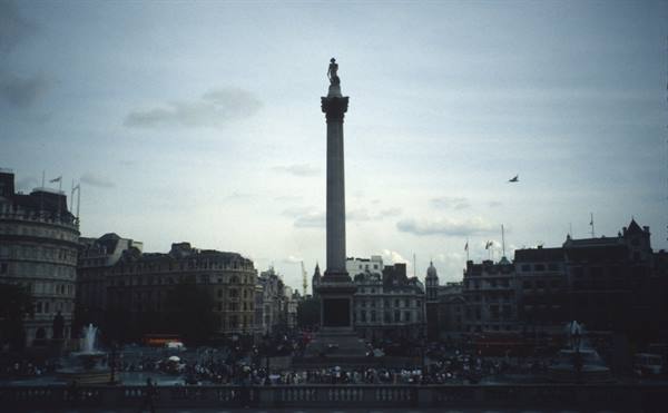 Nelson's Column at Trafalgar Square among historic buildings under cloudy sky
