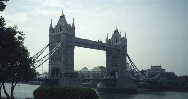 London's Tower Bridge in grey stone under cloudy sky, over the Thames