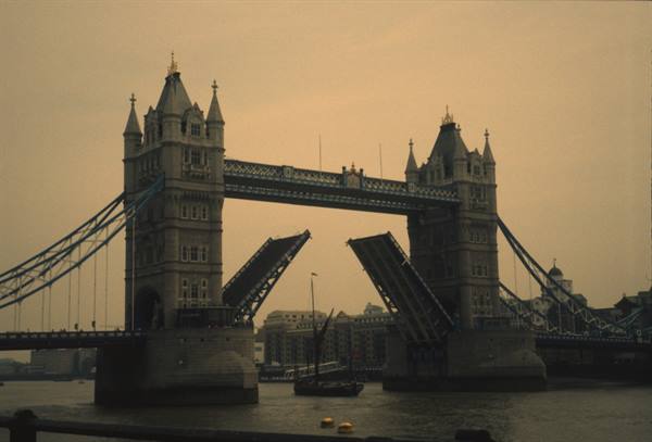 London's Tower Bridge opened over the Thames, a boat passing beneath the raised bascules