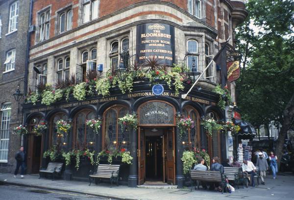 The Bloomsbury pub in London, red brick with hanging flowers and people seated outside
