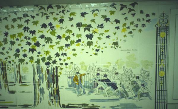 Painted ceramic tiles showing leafy trees and a fleeing crowd by a gate