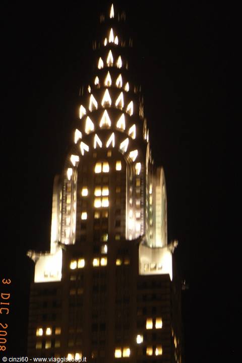 Illuminated spire of the Chrysler Building at night in New York, lit windows