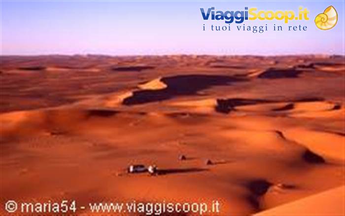 4x4 jeep amid orange sand dunes of the Sahara desert