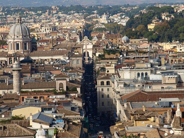 Via del Corso seen from above in Rome, terracotta rooftops, churches and domes in daylight