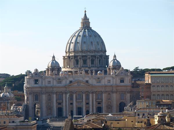 St. Peter's dome in Rome rises above the rooftops, clear morning light