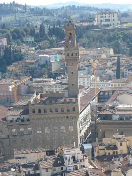 Palazzo Vecchio in Florence, stone tower rising above rooftops and hills