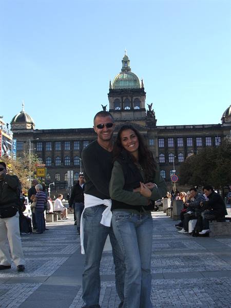 Couple embracing on Wenceslas Square in front of Prague's National Museum