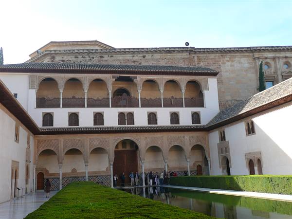 Arches and portico at the Alhambra in Granada, visitors along the pool