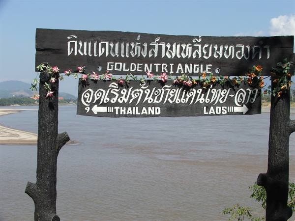 Wooden Golden Triangle sign with flowers before the Mekong river