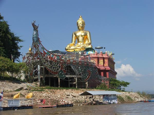Large golden seated Buddha atop metal ship sculpture, temple by the Mekong, Chiang Saen