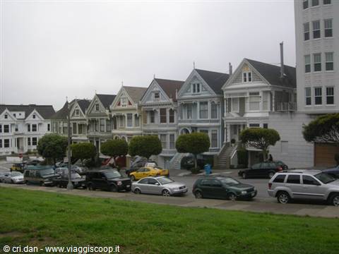 Victorian Painted Ladies houses at Alamo Square with parked cars under gray sky