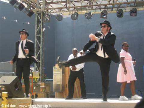 Blues Brothers tribute dancer in black suit kicks on outdoor stage