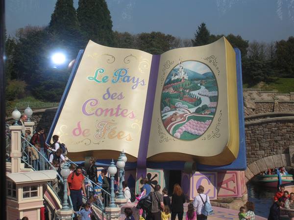Visitors in front of the giant open storybook Le Pays des Contes de Fées, Disneyland Paris
