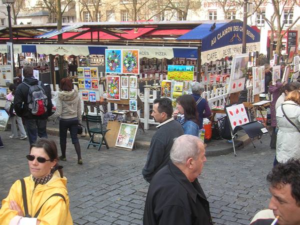 Place du Tertre in Montmartre, painters with canvases and tourists near cafes