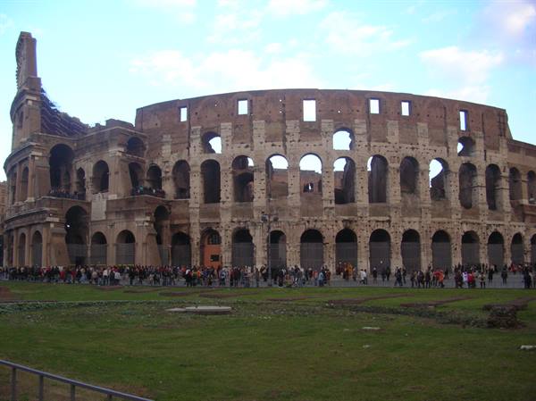 Tourists queueing in front of the Colosseum's brick arches, Rome