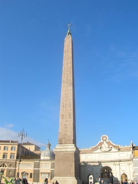 Egyptian obelisk topped with a cross at Piazza del Popolo, Rome, under blue sky