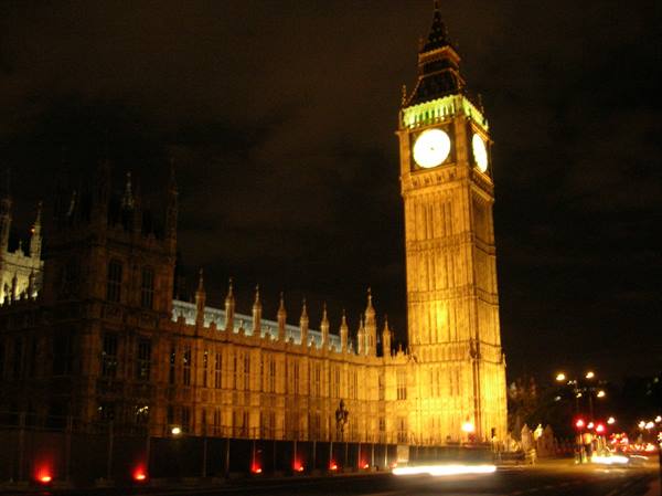 Big Ben and Westminster Palace lit up at night, blurred car lights