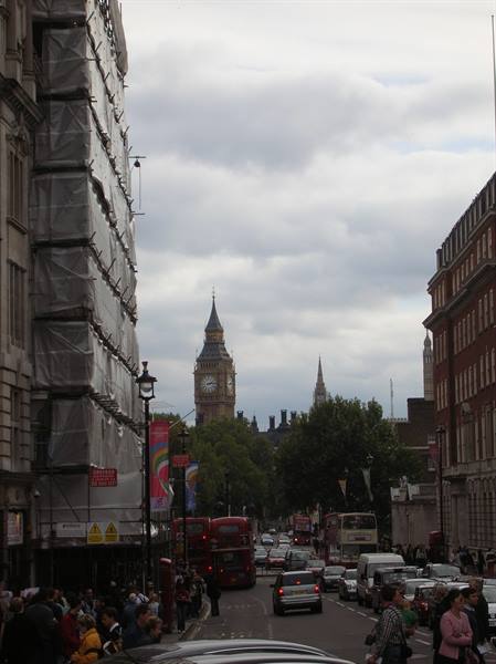 Busy Whitehall street with Big Ben clock tower under cloudy sky