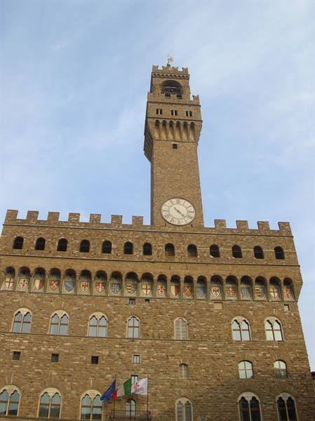Palazzo Vecchio in Florence, stone tower with clock and coats of arms