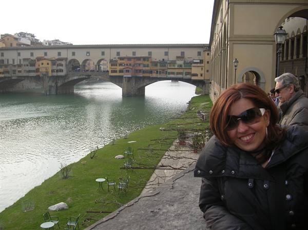 Smiling woman in front of Ponte Vecchio over the Arno, Florence