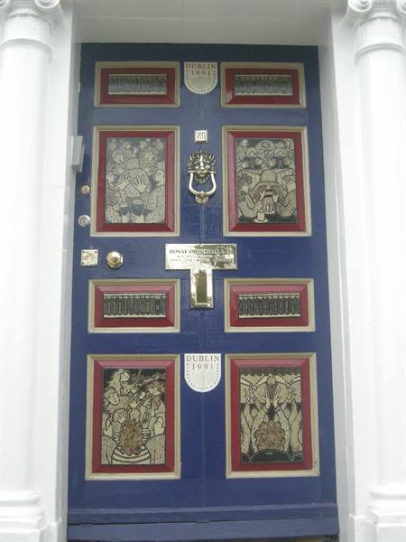 Blue door with illustrated panels, brass knocker, Dublin 1991 plaque
