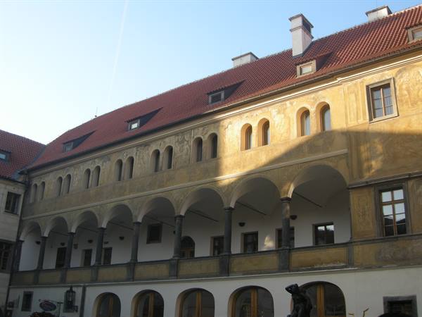 Renaissance arcade facade with red tiled roof in sunlight, Prague