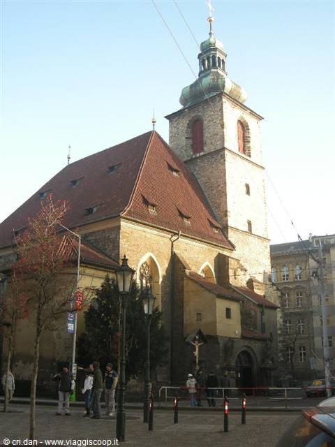 Church of the Holy Spirit in Prague, stone and red tiles, people strolling below
