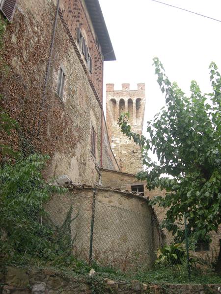 crenellated stone tower above ivy-covered houses in a medieval village