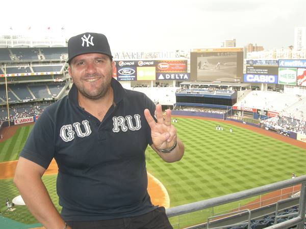 Fan wearing Yankees cap flashes peace sign at Yankee Stadium, New York