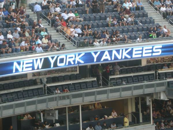Stands at Yankee Stadium, New York, fans seated under the glowing Yankees sign