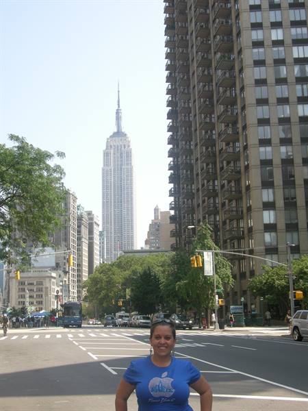 Smiling woman on a New York street with the Empire State Building