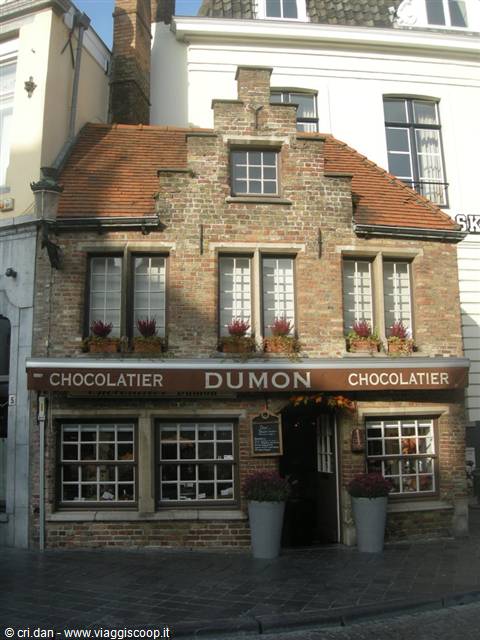 Brick façade of Dumon chocolatier in Bruges, flowers at the windows