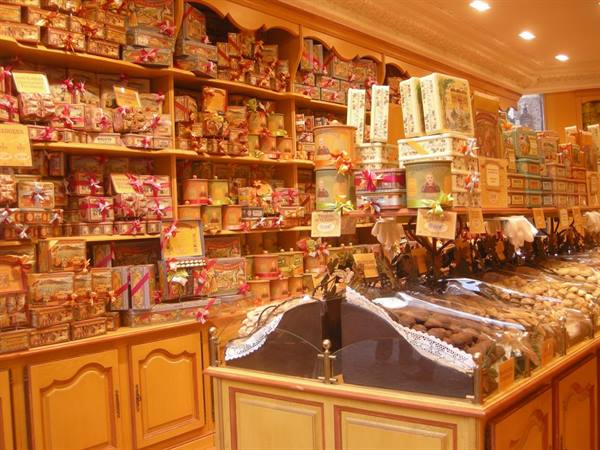 Wooden shelves filled with candy boxes in a warm-lit confectionery shop