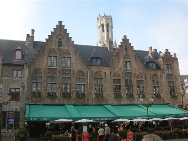 Stepped-gable brick houses and restaurant umbrellas on the Markt, Bruges