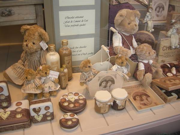 Chocolate shop window with plush teddy bears, chocolate boxes and cream jars