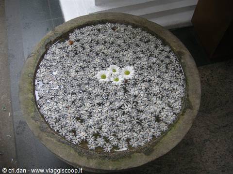 Inlaid stone flower in a round granite basin, natural light