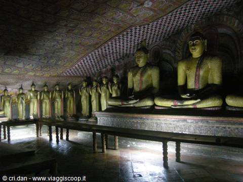 Seated and standing Buddha statues inside Dambulla painted cave temple