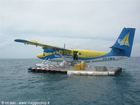 Yellow and blue Trans Maldivian seaplane moored at the floating platform