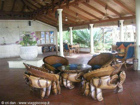 Open-air lobby with carved wooden crab-shaped armchairs around a round table