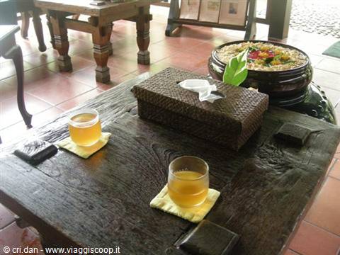 Two glasses of tea on dark wooden tray, woven box and bowl