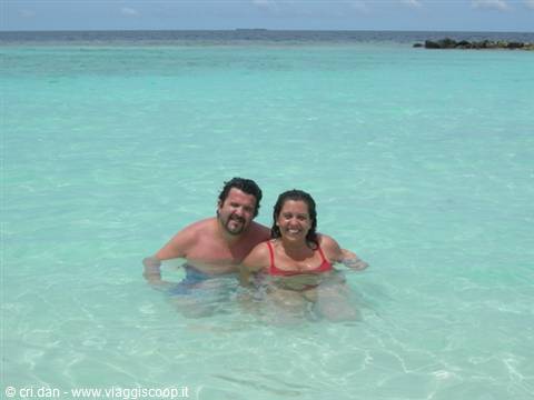 Couple in crystal-clear turquoise water, woman in red bikini, lagoon