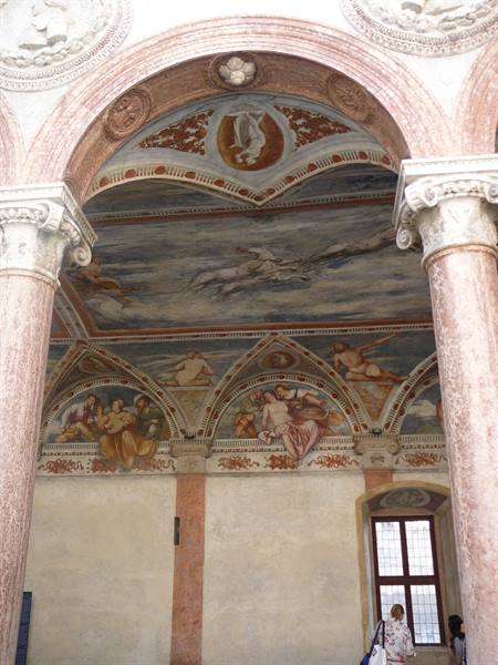 Pink marble arch and Renaissance frescoes in Padua's courtyard