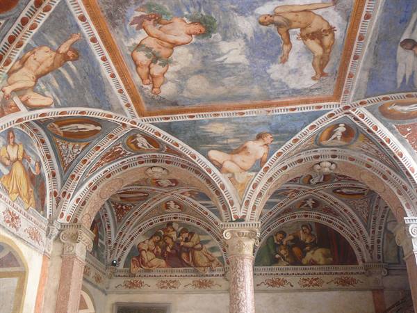 Frescoed vaults with nude figures and putti above marble columns