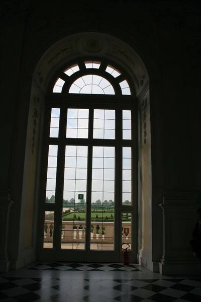 Arched multi-paned window overlooking the baroque gardens of Venaria Reale