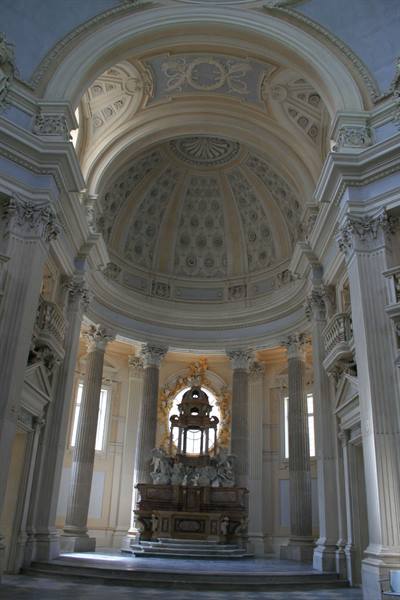 Baroque apse with Corinthian columns, frescoed dome and marble altar in soft light