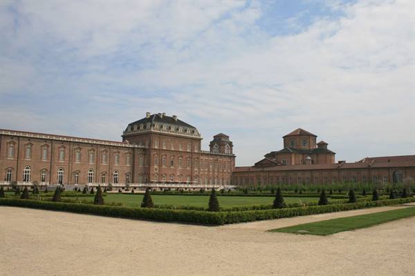 Reggia di Venaria Reale: brick baroque facade and clipped gardens under cloudy sky