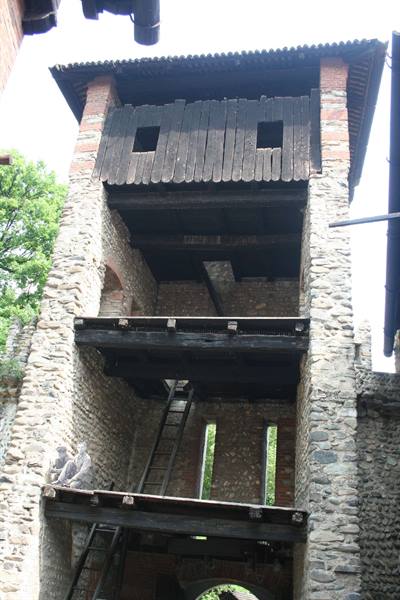 Medieval stone gate tower with wooden hoarding and ladders, Candelo ricetto