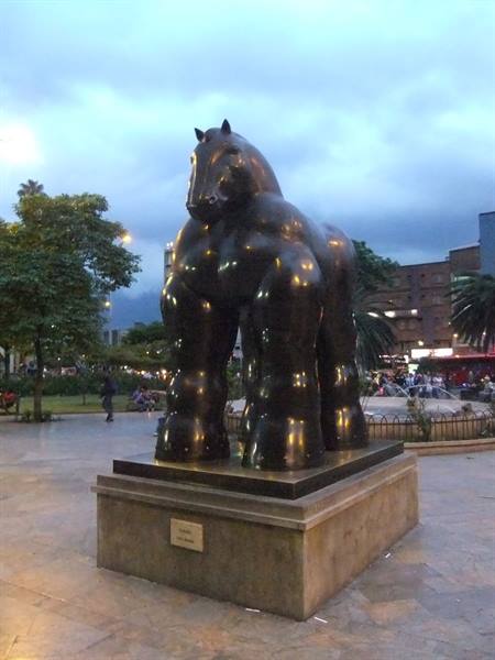 Botero's bronze Horse sculpture in a city square at dusk