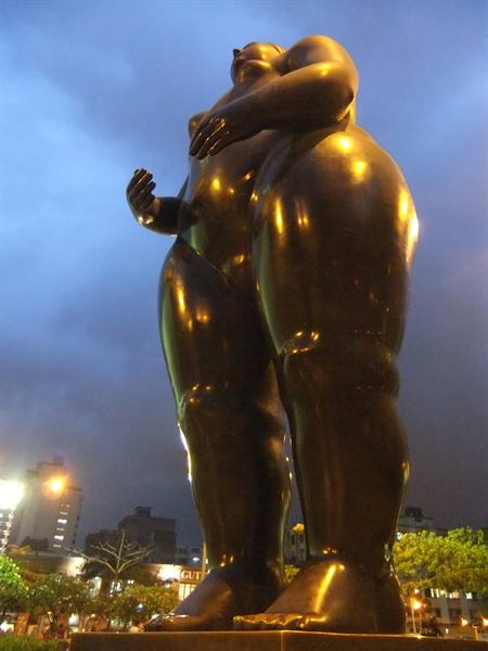 Botero bronze sculpture of a full-figured woman glowing at dusk, Medellín
