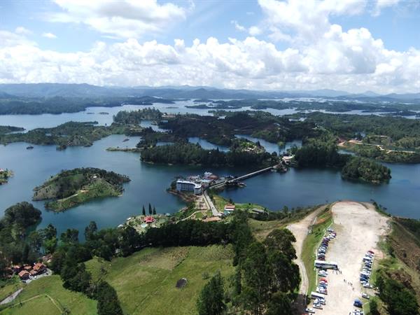 Guatapé reservoir, green islands scattered on blue water and dam, seen from above